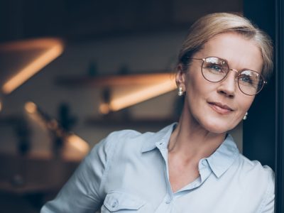portrait of pensive woman in eyeglasses looking away